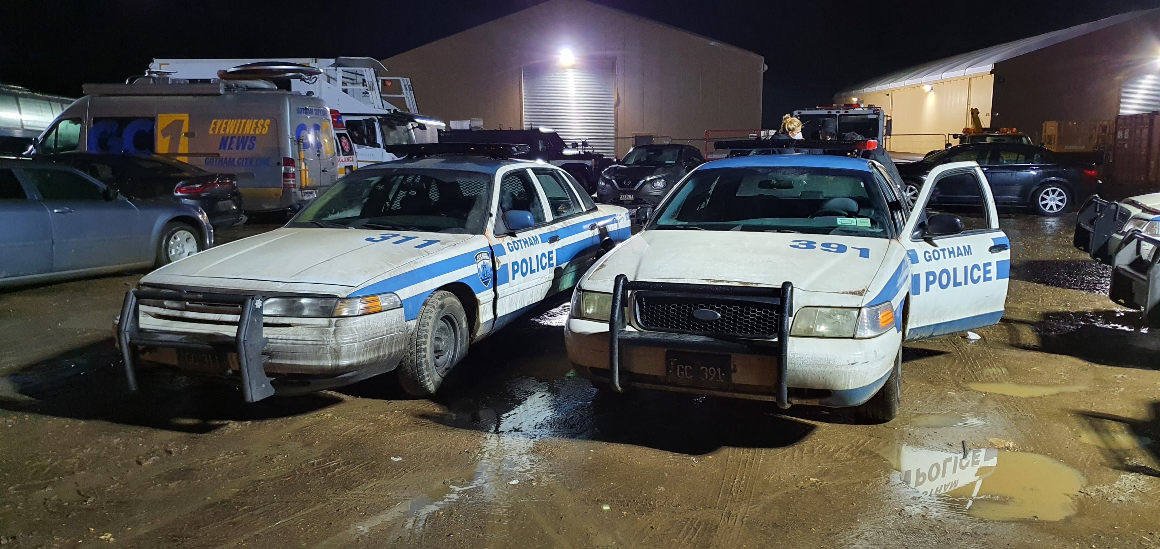 Gotham City Police cars on a film production backlot at night