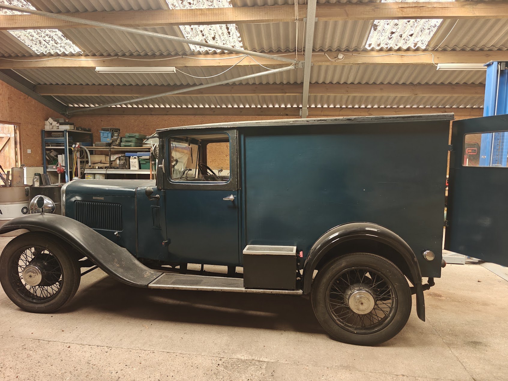 Side profile of the 1933 Austin Six baker's van in petrol blue with black wings and side-mounted spare wheel