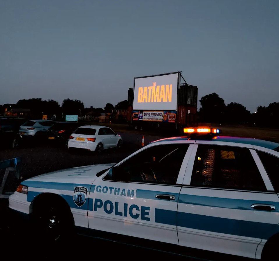 The screen-used Gotham Police car at night in front of a The Batman outdoor cinema screen