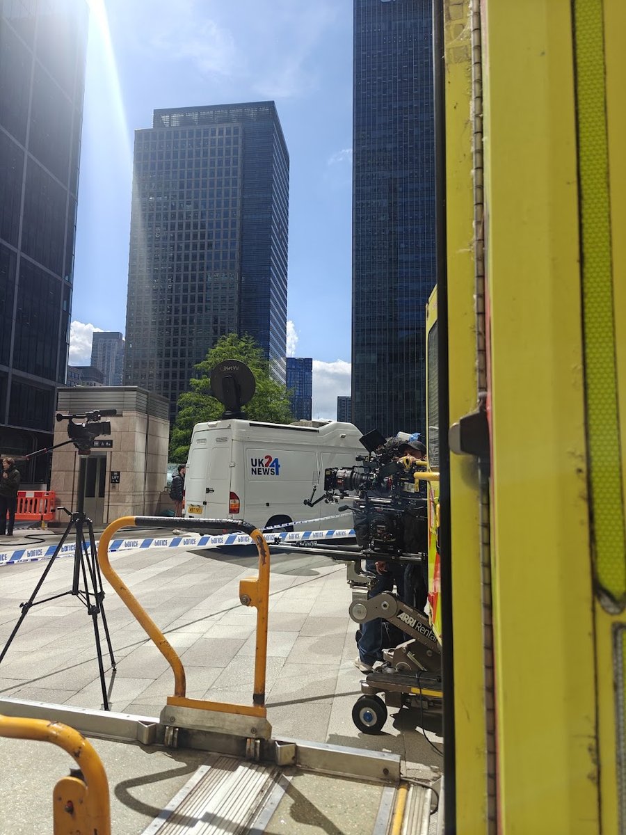Camera crew filming beside the outside broadcast news van on a London location