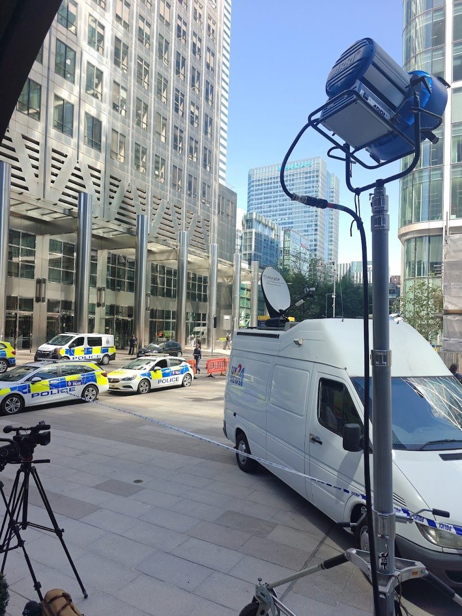 Outside broadcast van with satellite dish and mast deployed near Canary Wharf, London