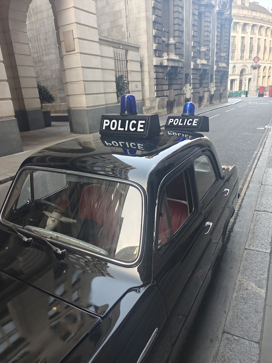 Classic police car with illuminated roof signage and livery detail